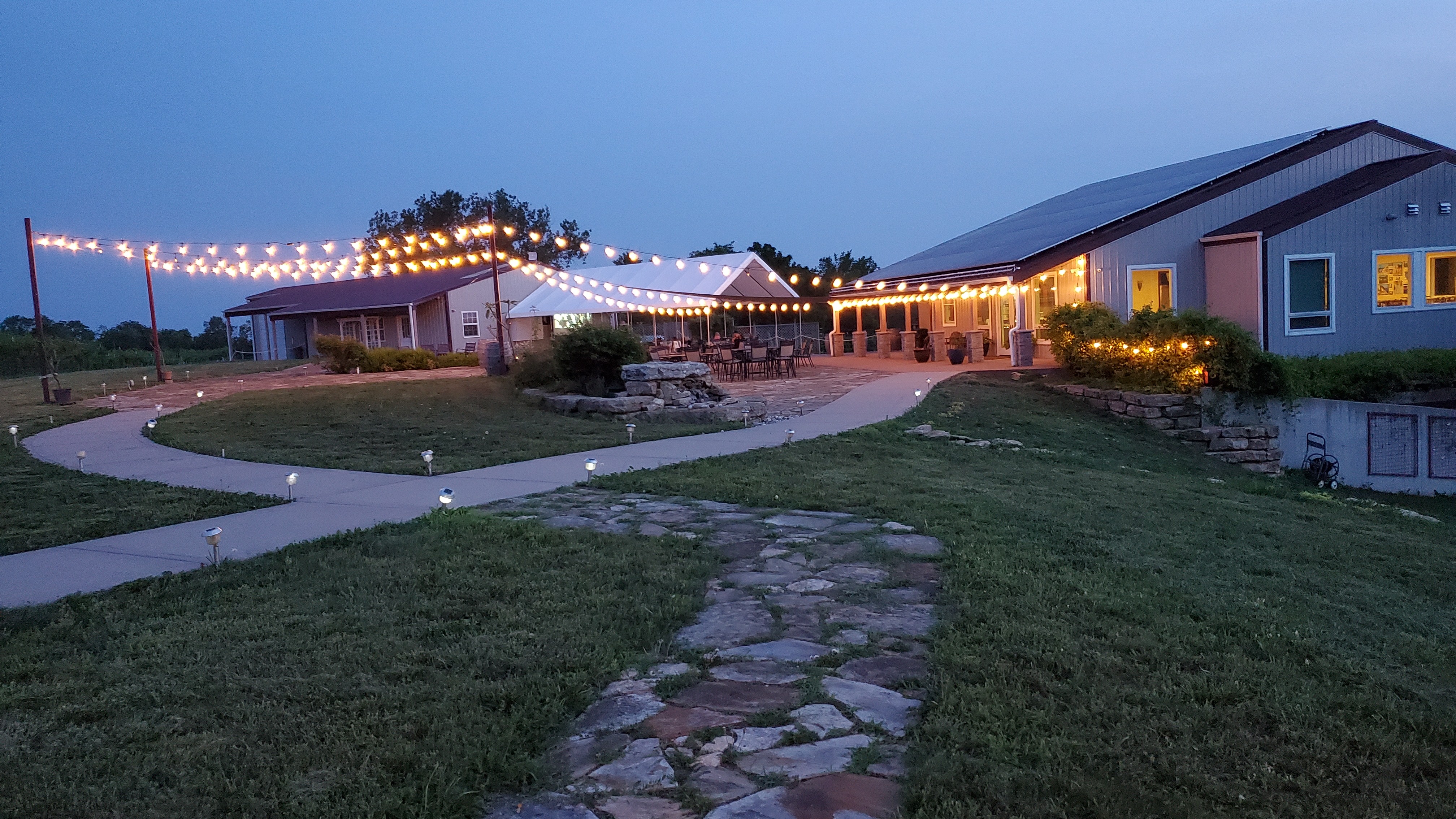 Fence Stile patio and event space lit for an evening gathering