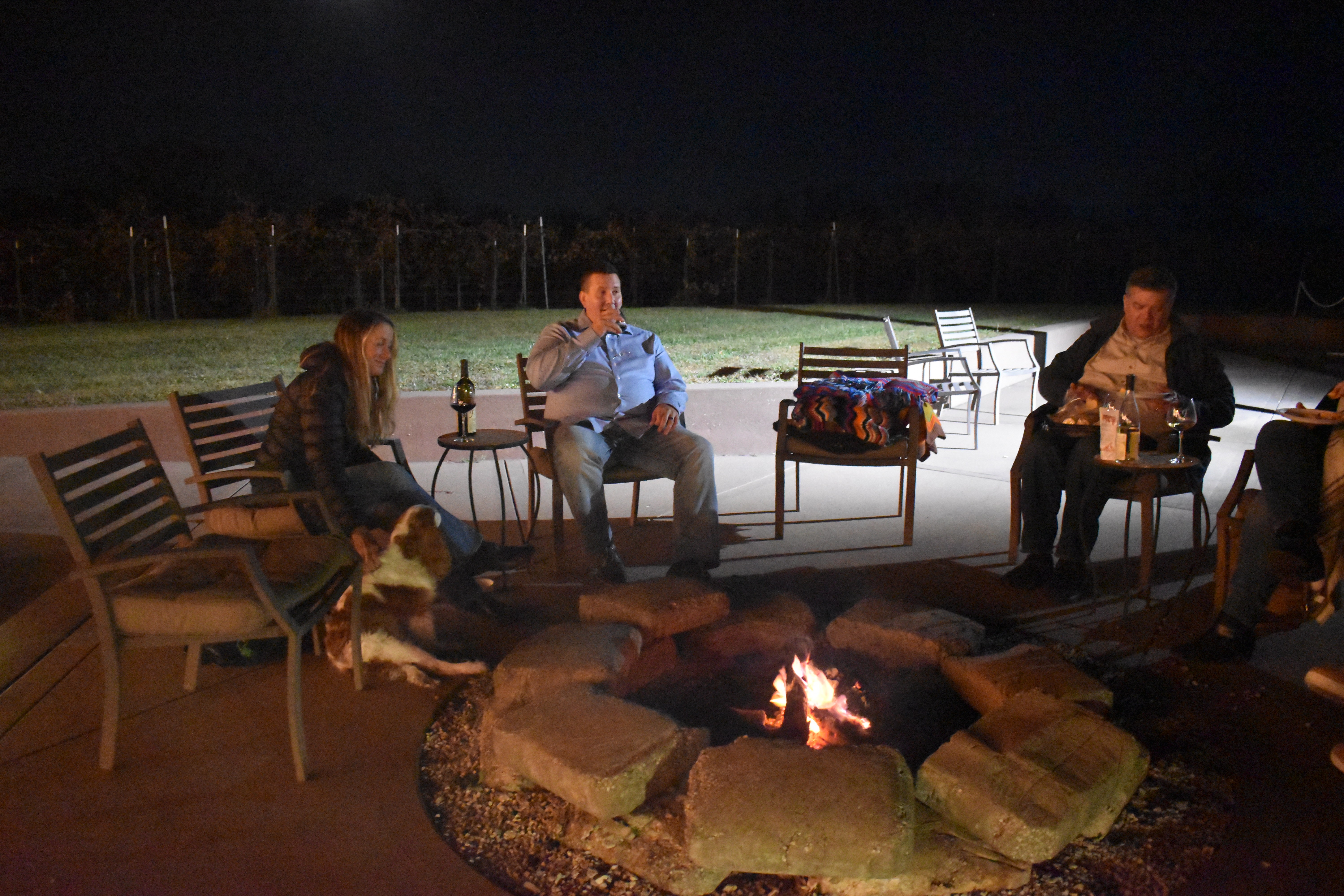 Guests gathered around the firepit on the Fence Stile patio