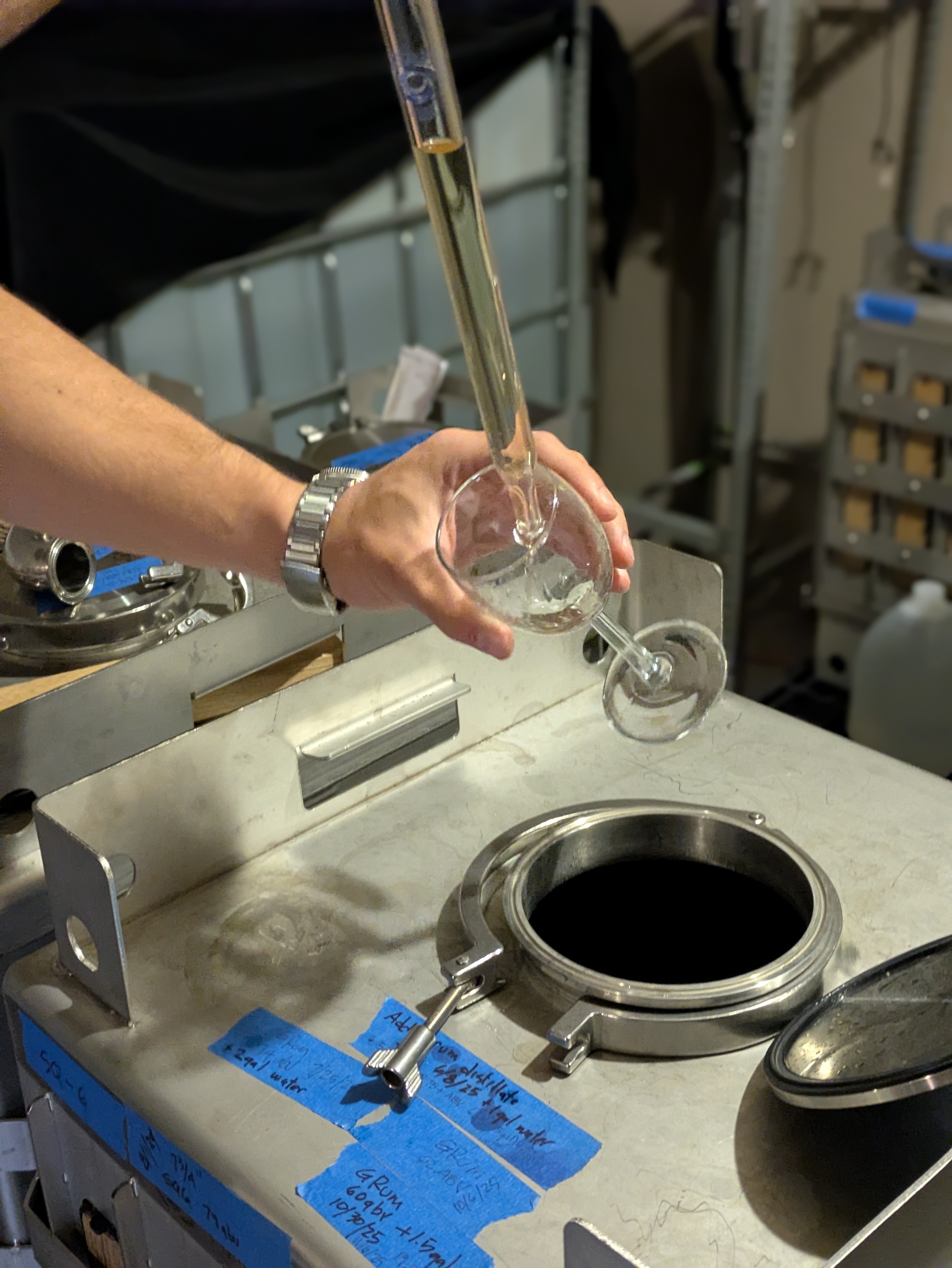Distillery team sampling a rum component for blending