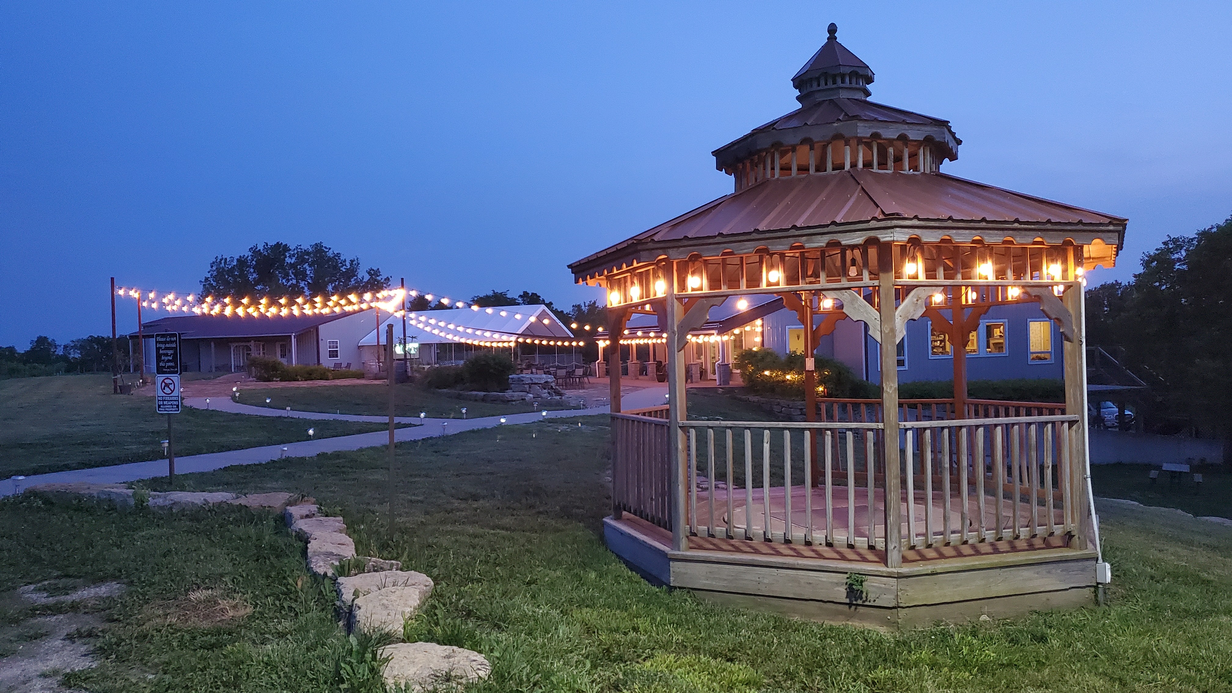 Illuminated gazebo and Fence Stile buildings at dusk