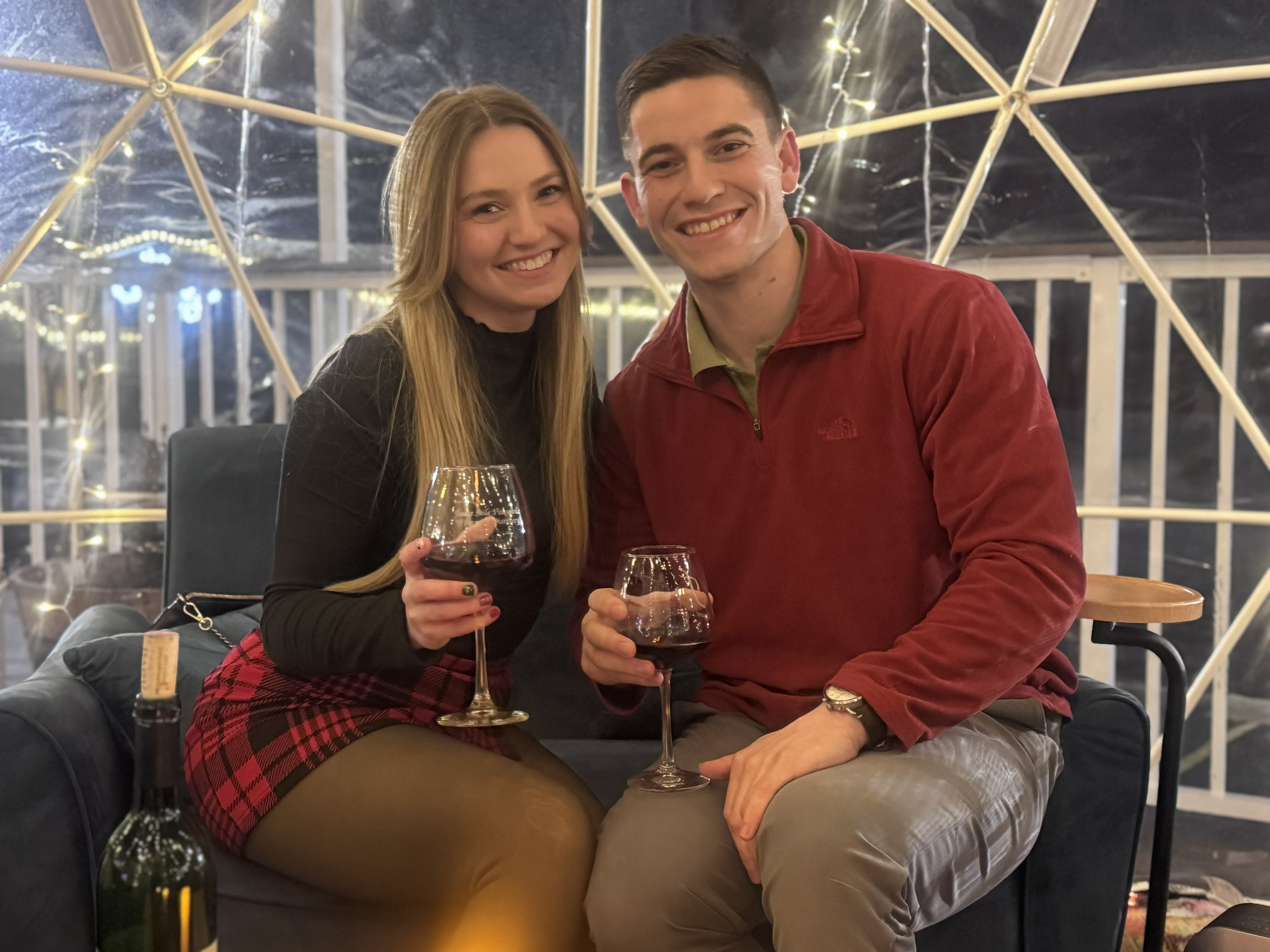 Couple enjoying wine inside a Fence Stile igloo