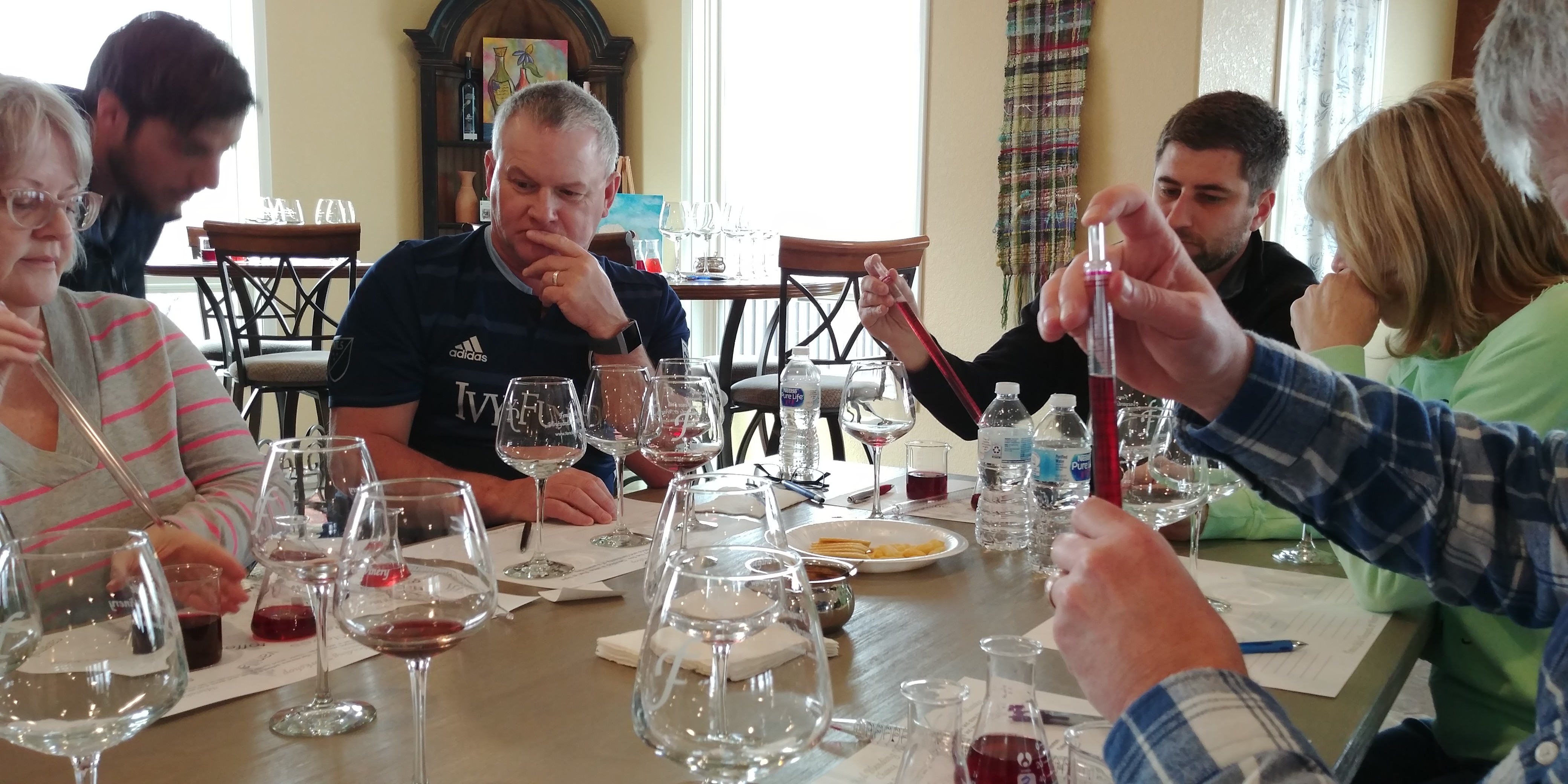 Group participating in a wine blending activity at Fence Stile