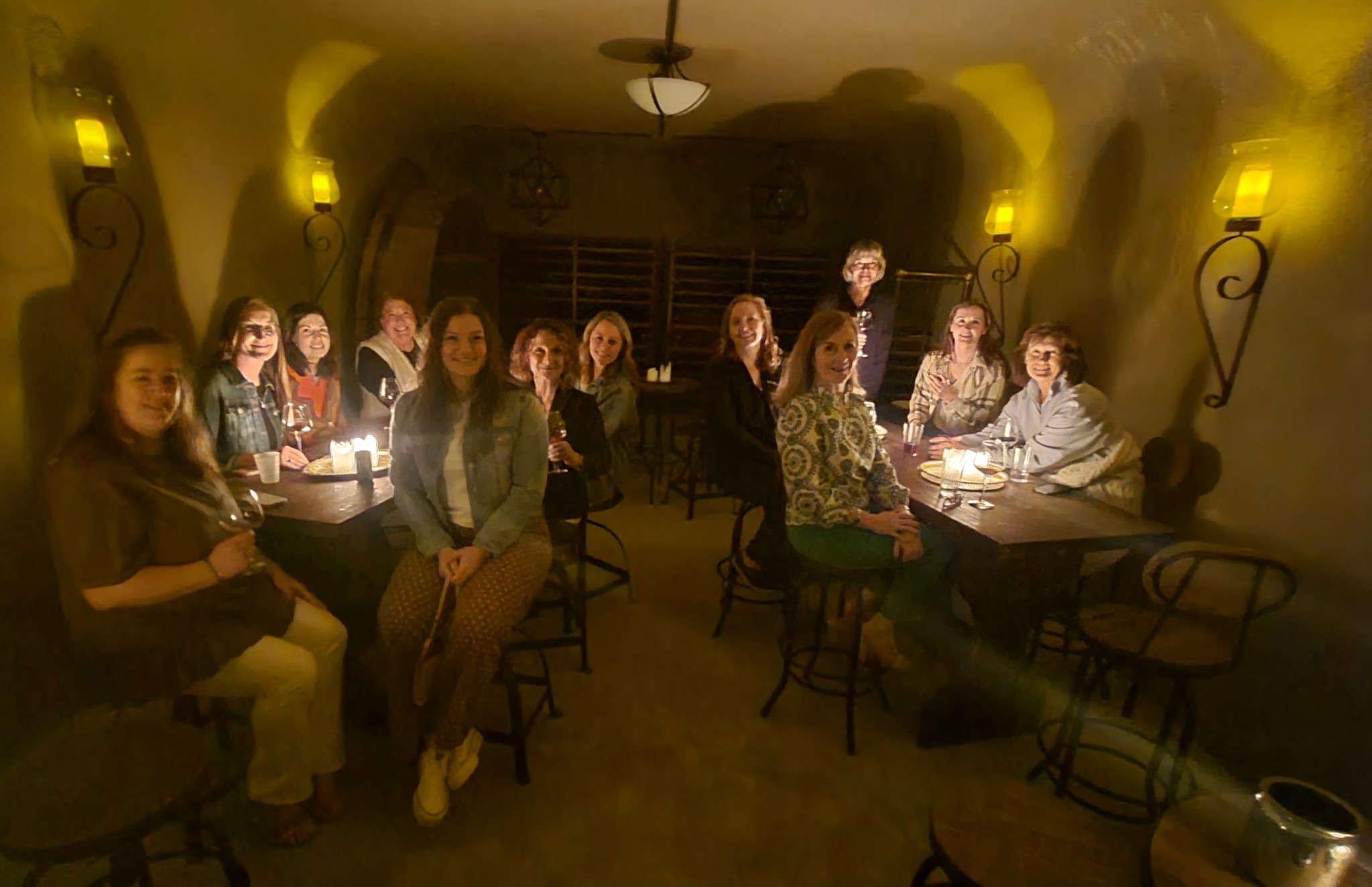 Friends enjoying a candlelit group experience inside the Fence Stile wine cave